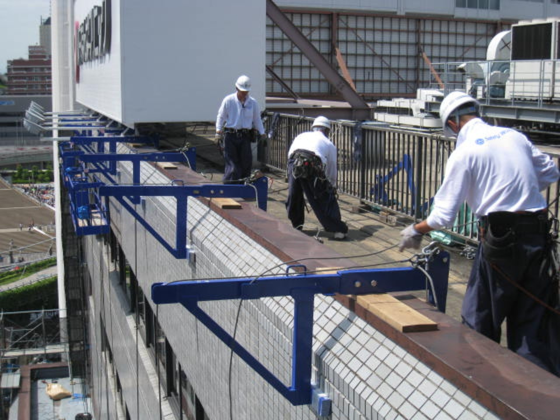 指さされた先を見上げる2人の作業員