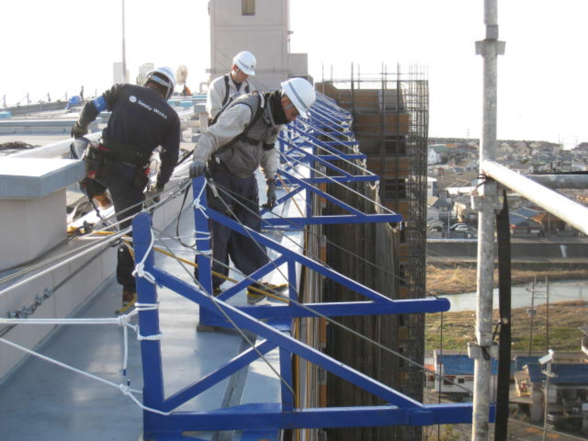 指さされた先を見上げる2人の作業員